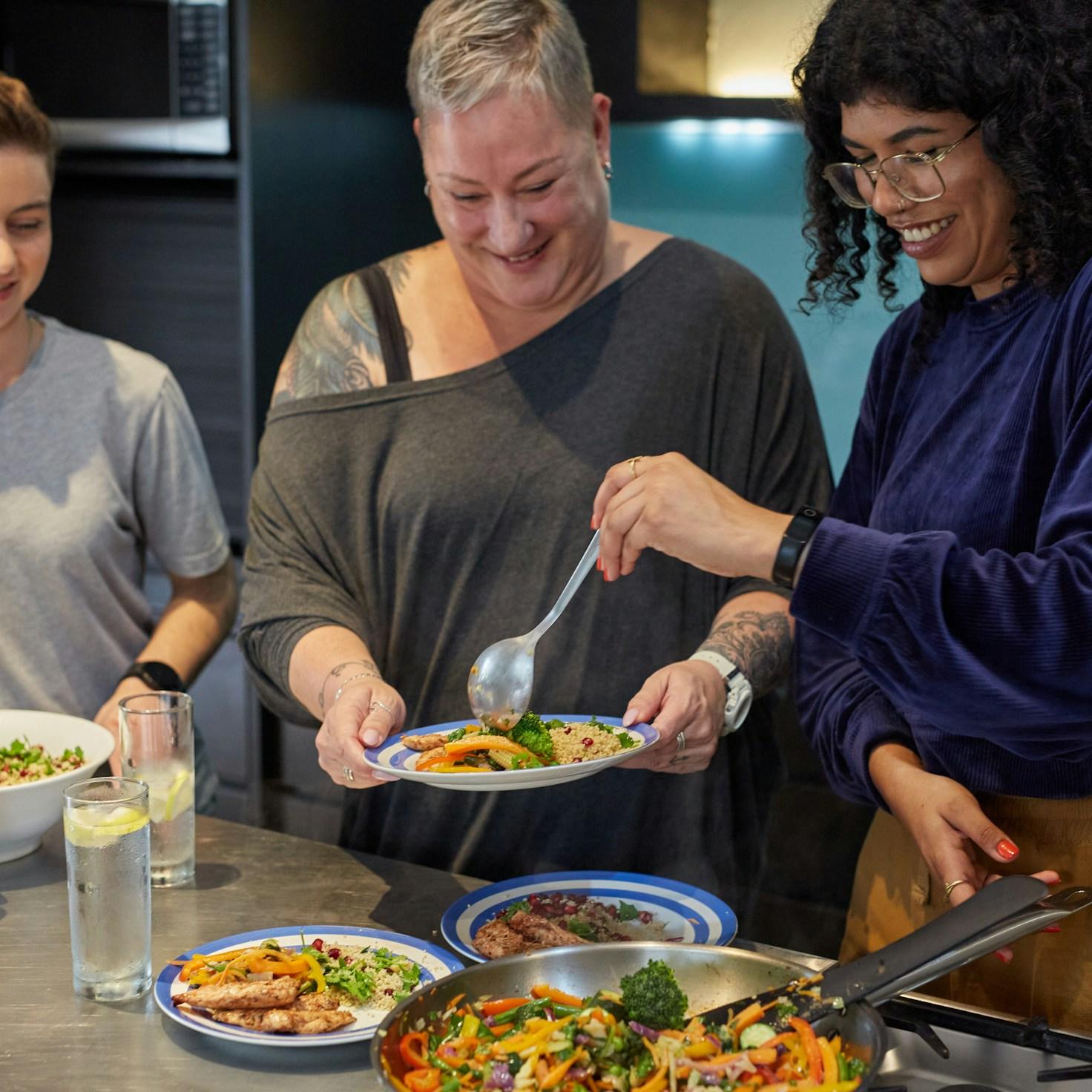 Community members collaborating in a modern kitchen space, sharing recipes and cooking techniques